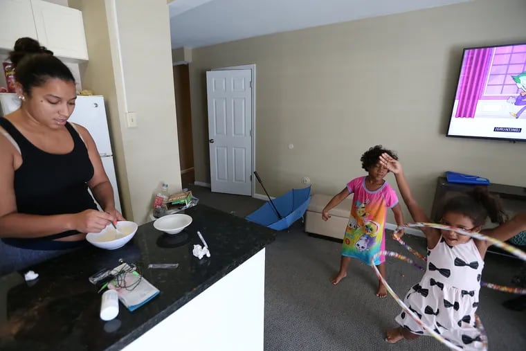 Delia Cruz, left, who evacuated from Puerto Rico after Hurricane Maria, makes breakfast as her daughters, Destiny, center, and Nagelie, right, play on June 26, 2018. The family has been living Windsor Suites Hotel in Philadelphia and have until Saturday, June 30, to leave hotel being paid for by FEMA.