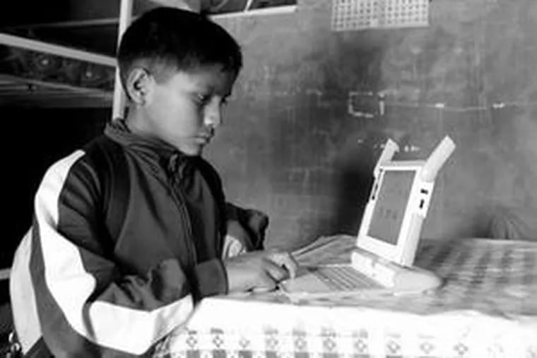 Kevin, 11, surfs the Internet at his Andean hilltop village in Peru. The laptops prompted families to move to the rural locale.
