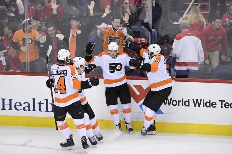 Philadelphia Flyers center Travis Konecny (11) celebrates his game-winning overtime goal with right wing Wayne Simmonds (17), center Sean Couturier (14) and defenseman Ivan Provorov, second from left, in an NHL hockey game against the Washington Capitals, Sunday, Jan. 21, 2018, in Washington. The Flyers won 2-1 in overtime.