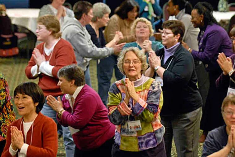 A traditional greeting is offered at a Shibashi Tai Chi workshop on Monday. &quot;It does my soul good to see all these women,&quot; said a Philadelphia pastor. (RON TARVER / Staff Photographer)