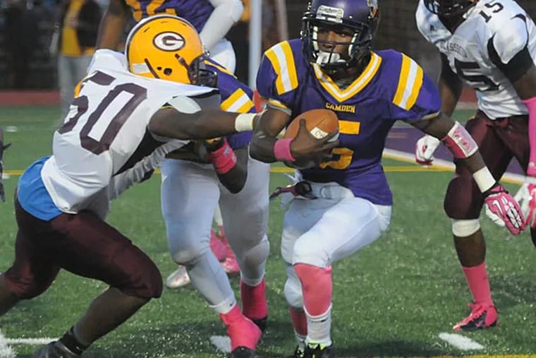 Camden's quarterback (right) runs a keeper in the first quarter as Glassboro's Kenyonn Jones moves in for the tackle. (Photo by Curt Hudson)