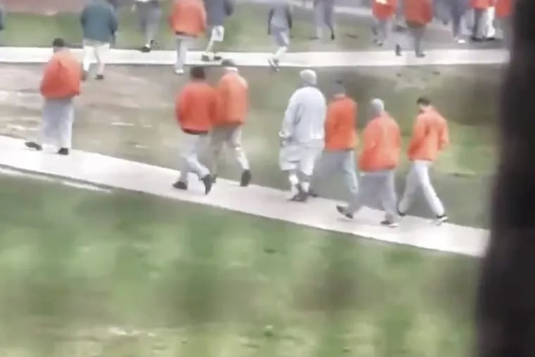 A still taken from a video posted to Twitter April 5 by an inmate at Fort Dix federal prison, shows prisoners milling about the recreation yard with little adherence to social distancing guidelines.