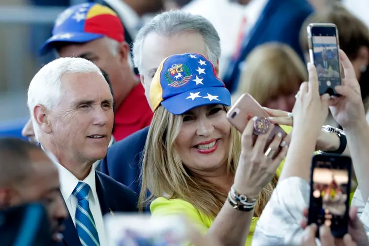 Vice President Mike Pence poses with Paula Tenreiro, who is wearing a cap with the design of the Venezuelan flag, following a tour on the USNS Comfort, Tuesday, June 18, 2019, in Miami. The hospital ship is scheduled to embark on a five-month medical assistance mission to Latin America and the Caribbean, including several countries struggling to absorb migrants from crisis-wracked Venezuela.