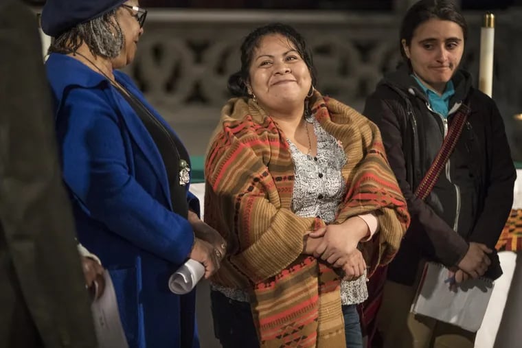 Carmela Apolonio Hernandez, center, smiles as speaker after speaker supports her cause for immigration relief during a press conference at the Church of the Advocate on Thurday.