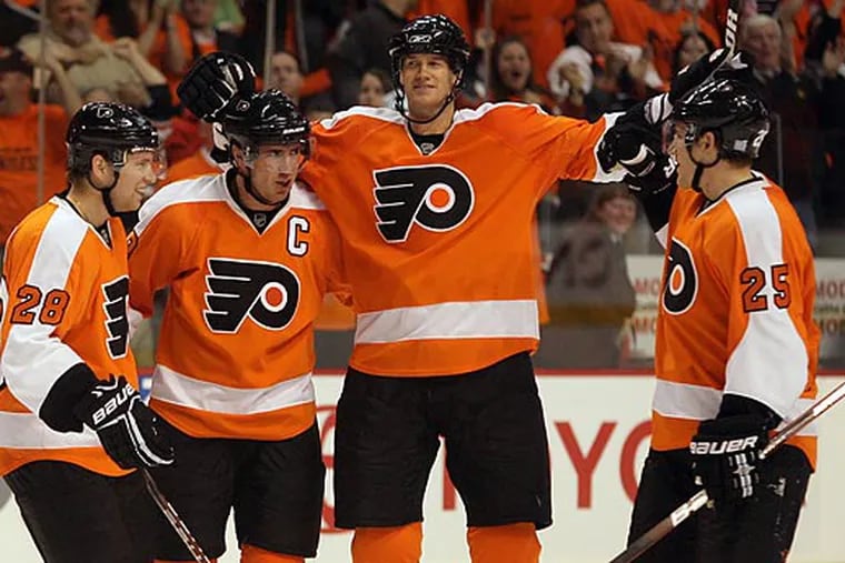 In a file photo (left to right), Claude Giroux, Mike Richards, Chris Pronger, and Matt Carle celebrate Richards' goal. Giroux passed Bobby Clarke as the longest-tenured captain in Flyers history Tuesday, and he said he models his leadership style after Richards.