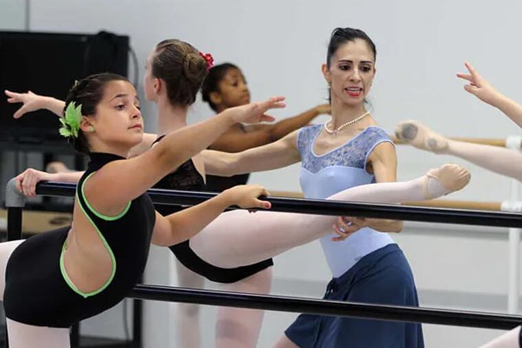 Principal instructor Arantxa Ochoa, center, helps a dancer work on her leg positioning during a summer class held at the Pennsylvania Ballet's new home at 323 N. Broad St. (Michael Bryant/Staff Photographer)