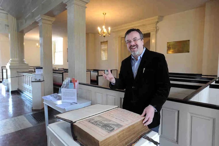 The Rev. Timothy Safford of Christ Church with the Vinegar Bible of 1717, so called because of its misspelling of &quot;vineyard.&quot;