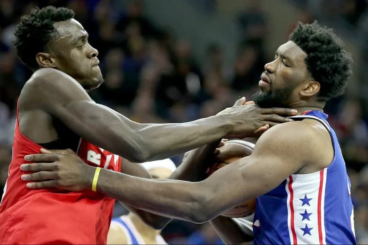 Joel Embiid, right, and the Raptorsâ€™ Pascal Siakam battle for control of the ball in the third quarter.