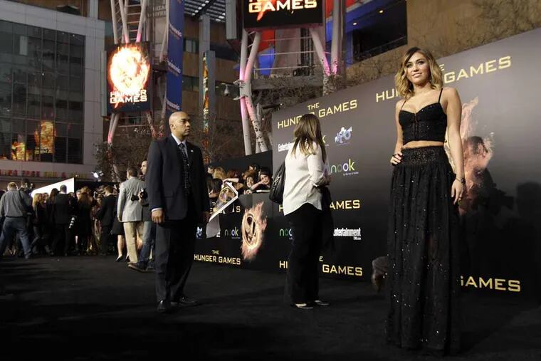 Miley Cyrus arriaves at the world premiere of "The Hunger Games" on Monday March 12, 2012 in Los Angeles. (AP Photo/Matt Sayles)