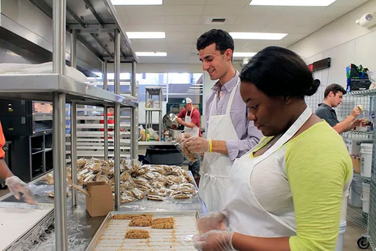 Tyeesha Butts and Jarrett Stein package the Rebel Bars that they will sell throughout the West Philadelphia Community. (CINDY STANSBURY / DAILY NEWS STAFF)