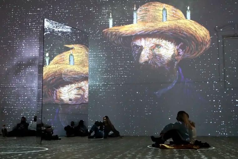 Patrons looking at images cast on the wall and reflecting mirror during a virtual display titled "Immersive Van Gogh" on Feb. 18, 2021, at the Lighthouse ArtSpace in Chicago.