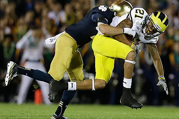 Michigan's Roy Roundtree is tackled by Notre Dame's Bennett Jackson. (Darron Cummings/AP)
