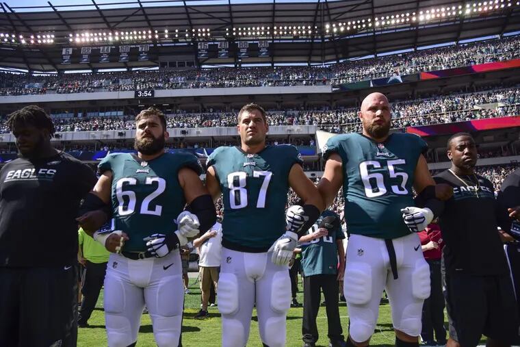 Eagles players Jason Kelce (left), Brent Celek and Lane Johnson hook arms during the playing of the national anthem before the game against the Giants at Lincoln Financial Field September 24, 2017. The Eagles won 27-24.
