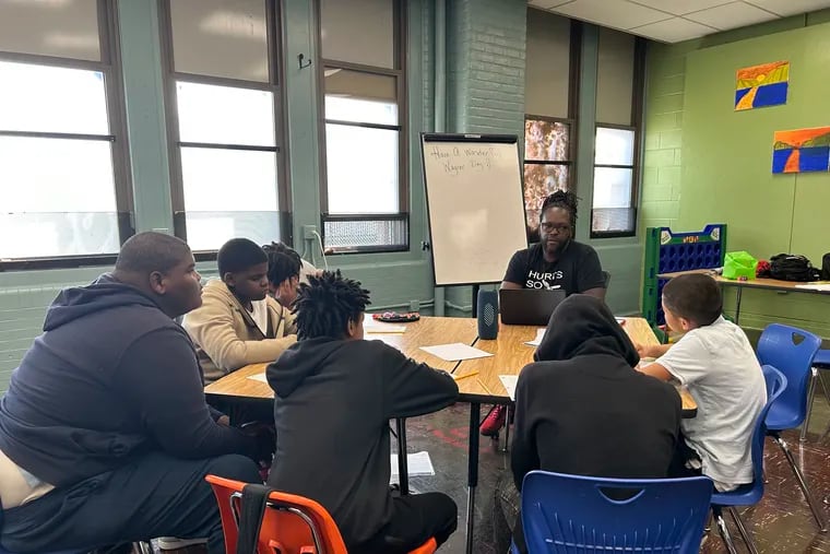 A group of boys from Wagner Middle School participate in ManUpPHL's mentoring program to stop gun violence. From left to right around the table are Malik Holden, Makhi McIntosh, TyJay Kent, Zaire Hardison, Dylan Rousseau and Nate White-Williams. Desmin Daniels (center) facilitated a conversation about where the boys feel safe in Philadelphia.