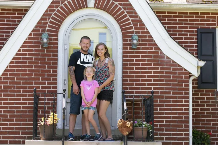 Jim, Amanda, and 7-year-old Hailey Meindl, on their front porch in Sellersville. "This is our last home," Amanda says.