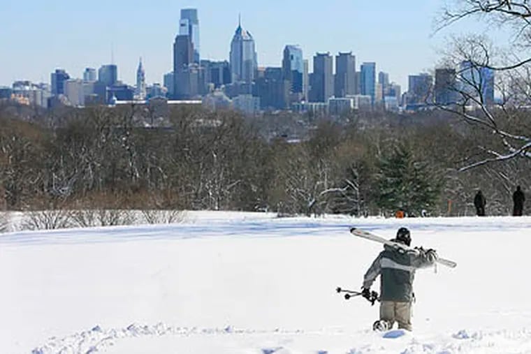 Ryan Megna, 28, of Manayunk, walks with ski gear in Fairmont Park over looking the Philadelphia Skyline. (Akira Suwa  /  Staff Photographer)