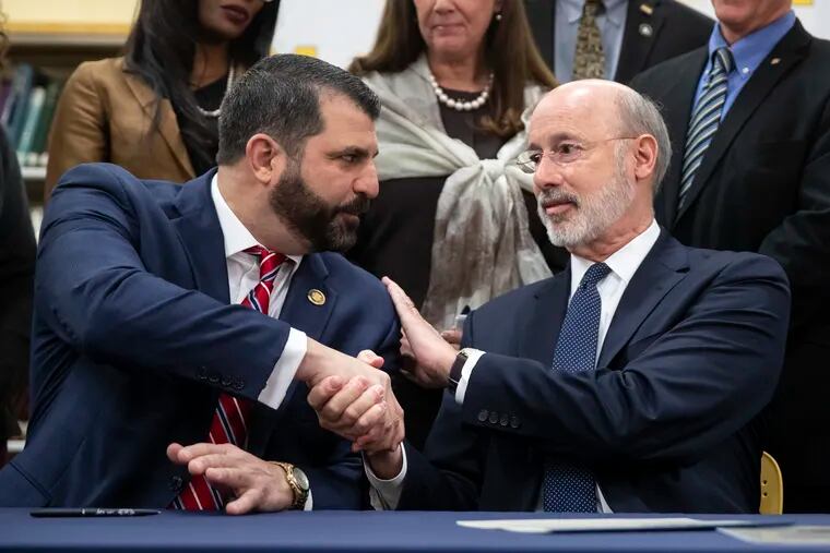 Pennsylvania Gov. Tom Wolf (right) shakes hands with Rep. Mark Rozzi, D-Berks, after signing legislation into law to expand the rights of child sexual abuse victims to sue in November 2019.