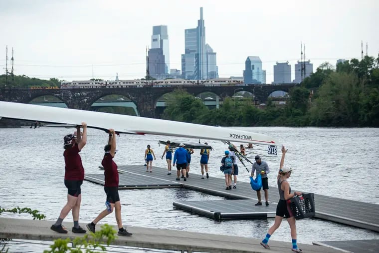Teams carry their boats down the docks in preparation for the first day of competitions in the Stotesbury Regatta in Philadelphia, Pa., on Friday, May 20, 2022.