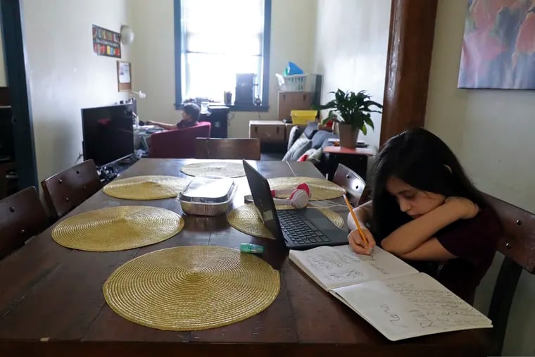 A child finishes her homework after her virtual school hours. (AP Photo/Shafkat Anowar)