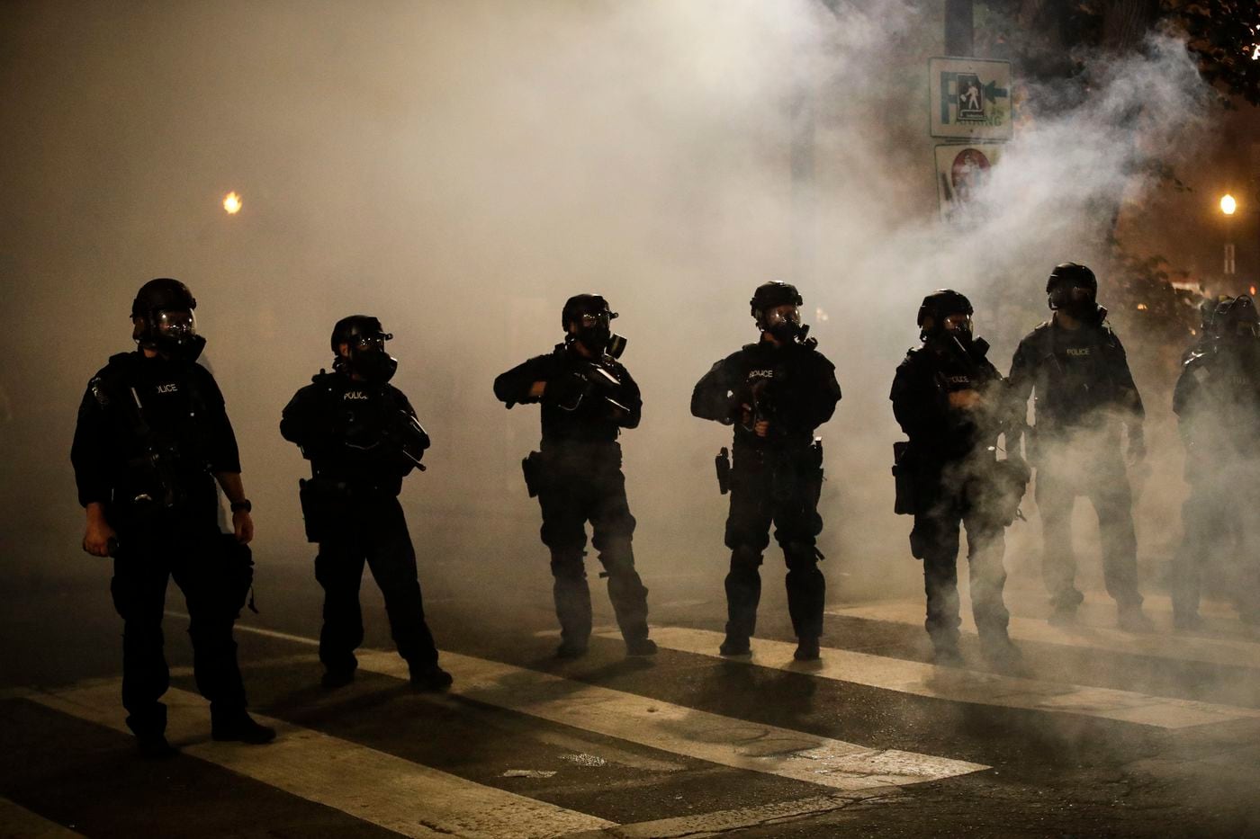Federal officers are surrounded by smoke as they push back demonstrators during a Black Lives Matter protest at the Mark O. Hatfield United States Courthouse Wednesday in Portland, Ore.