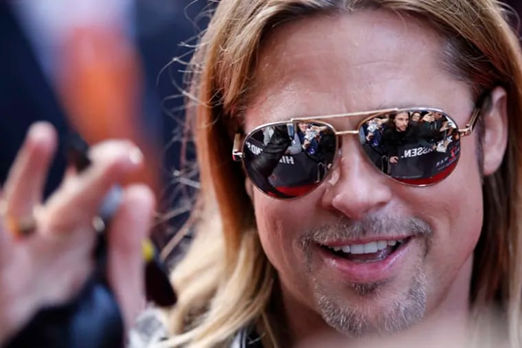 US actor Brad Pitt waves to fans in Berlin, Germany, Tuesday, June 4, 2013. On Thursday, he introduced "World War Z" to 400 fans at the King of Prussia Regal Cinemas. (AP Photo/Ferdinand Ostrop)