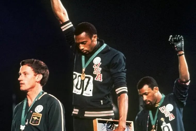 Australia's Peter Norman (left) stood on the podium at the 1968 Summer Olympics in Mexico City as Americans Tommie Smith (center) and John Carlos raised their gloved fists in a human rights protest.