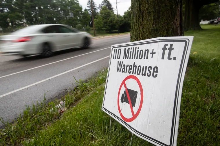 There is community and local business opposition to a giant UPS warehouse in this residential area. A car goes by a sign against it on Red Lion Road on June 2, 2022.