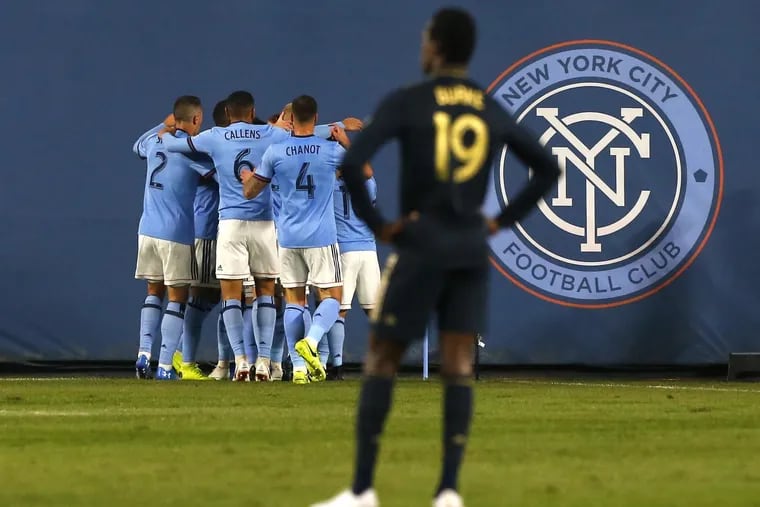 Union forward Cory Burke watches as New York City FC players celebrate one of their team's first-half goals.