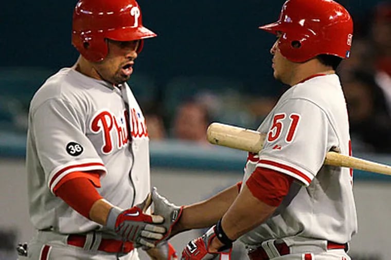 Shane Victorino (left) scored both runs in the Phillies' win. (Lynne Sladky/AP)