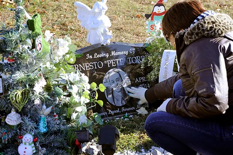 Cary Soldevila visits the Arlington & Bethel Cemetery grave of her son, Ernesto Torres, 22, on December 31, 2014. He was killed by gunfire in Camden. ( TOM GRALISH / Staff Photographer )