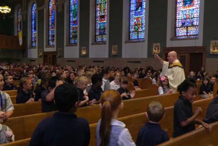 PHOTOS: COURTESY OF ST. TIMOTHY The Rev. Michael Olivere , pastor at St. Timothy's, celebrates the end-of-year closing Mass for Blessed Trinity students.