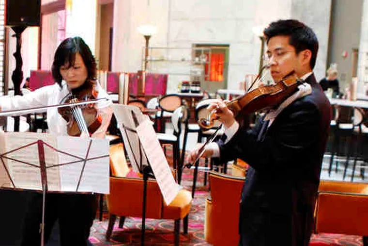 At a media gathering, above, orchestra members (from left) David Kim, Anna Marie Petersen, and Daniel Han play. At left, orchestra president Allison B. Vulgamore stands next to Mayor Nutter.
