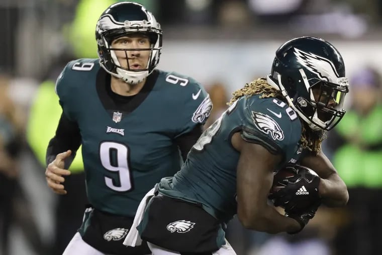 Eagles’ quarterback Nick Foles (left) hands the ball off to running back Jay Ajayi. Foles has used RPO’s, where he has the option to hand the ball off or take it and throw it, with great success during the playoffs.