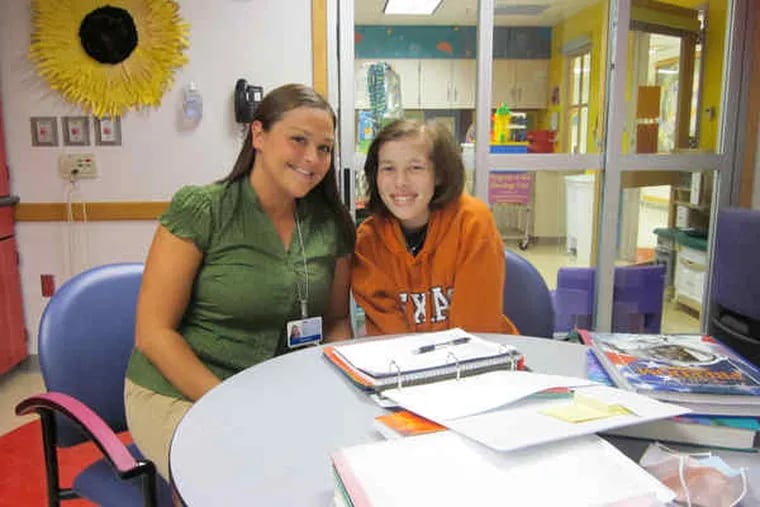 Tenth grader Carly Stephens and teacher Jamie Johnstone at Children's Hospital of Philadelphia. The hospital's school program &quot;is great for her,&quot; says Carly's mother. And the student herself says taking tests is less stressful there than at her school.