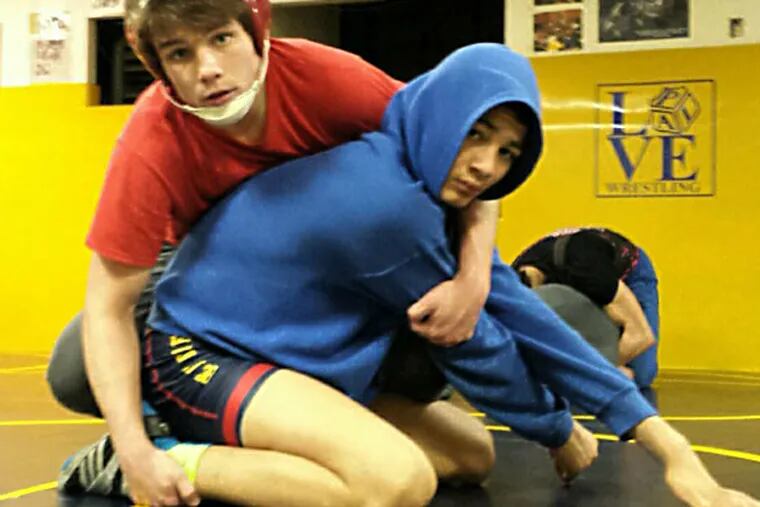 St. Joseph's Prep senior Bobby Endy (top) works out with seventh grader Angel Garcia at the Rizzo PAL in Port Richmond. The unbeaten 152-pounder is seeking a state title. (Ed Schneider)