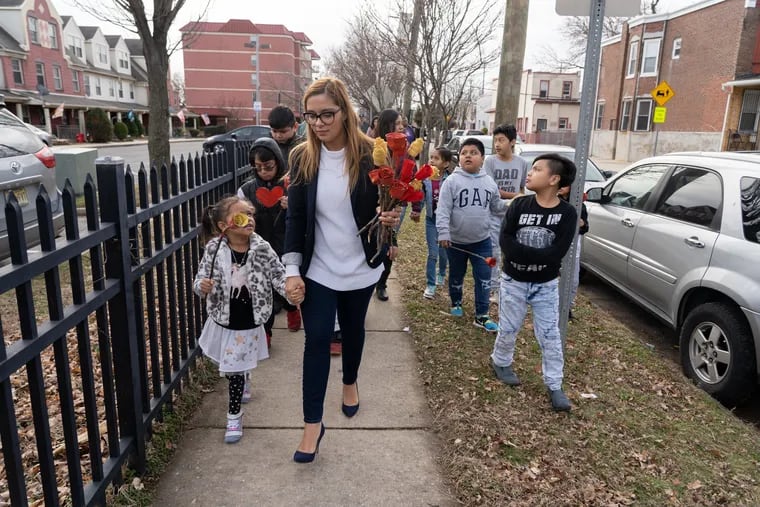 Councilwoman Felisha Reyes-Morton leads a walk to a community garden to decorate with roses and hearts made out of recycled materials in Camden on Saturday, Jan. 11, 2020.