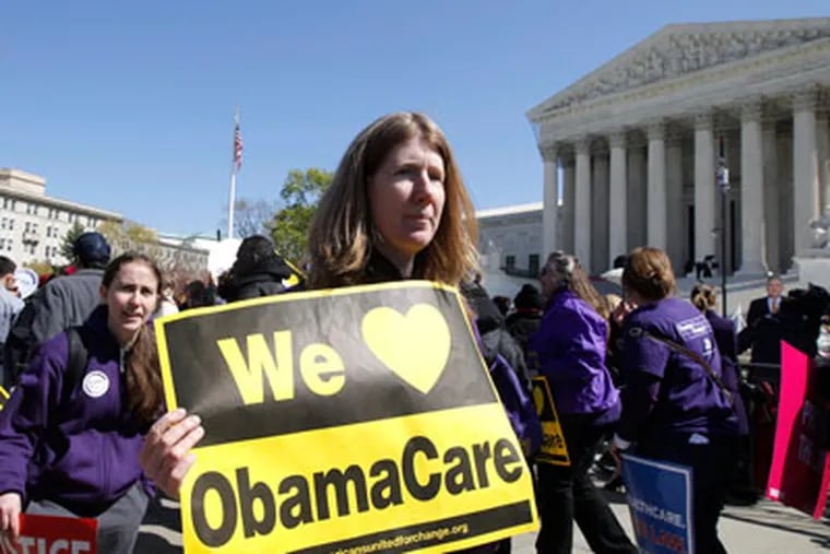 Backers of the health care law march in front of the Supreme Court in May.