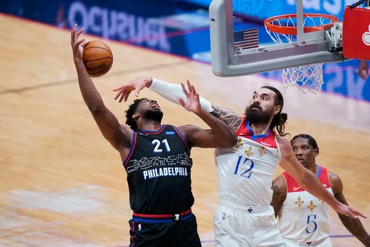 Philadelphia 76ers center Joel Embiid (21), who struggled and scored just 14 points, is fouled by the New Orleans Pelicans' Steven Adamsas he goes to the basket in the first half.