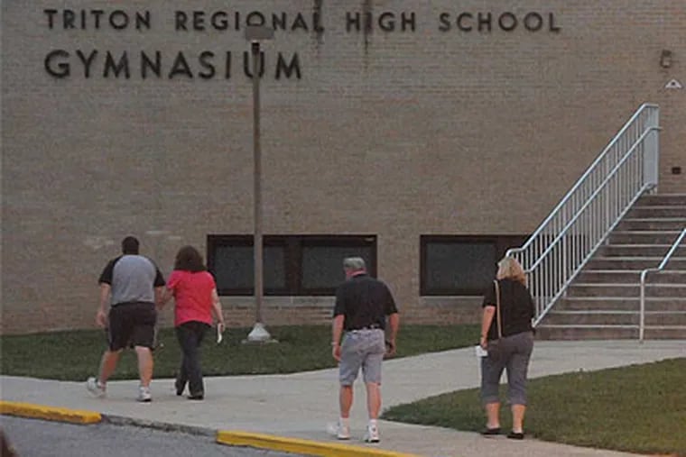 People walk toward Triton Regional High School in Runnemede, N.J. for Back-to-School night. (Curt Hudson / For the Daily News)
