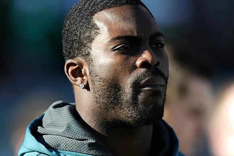 Philadelphia Eagles quarterback MichaelVick watches the game from the bench in the first half of an NFL football game against the Washington Redskins, Sunday, Dec. 23, 2012, in Philadelphia. (AP Photo/Michael Perez)