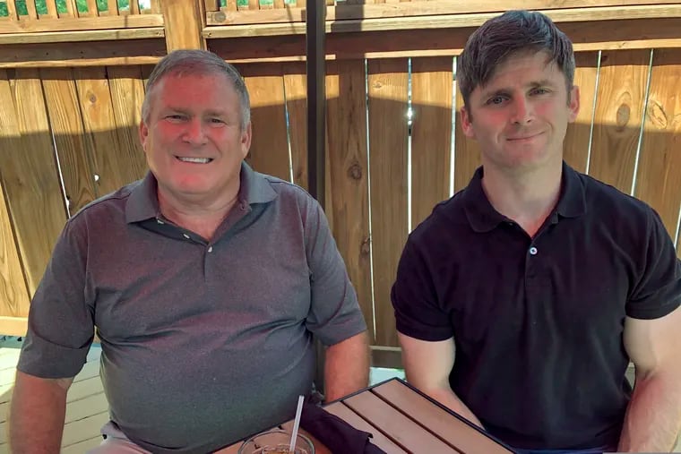 This photo from June 26 shows Buck Newsome, left, a baby boomer, and his son, Chris Newsome, of the Millennial generation, as they pose for a photo while having lunch together in Newtown, Ohio.