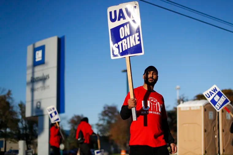 In this Oct. 9, 2019, file photo a member of the United Auto Workers walks the picket line at the General Motors Romulus Powertrain plant in Romulus, Mich. General Motors CEO Mary Barra joined negotiators at the bargaining table Tuesday, Oct. 15, an indication that a deal may be near to end a monthlong strike by members of the United Auto Workers union that has paralyzed the company’s factories.