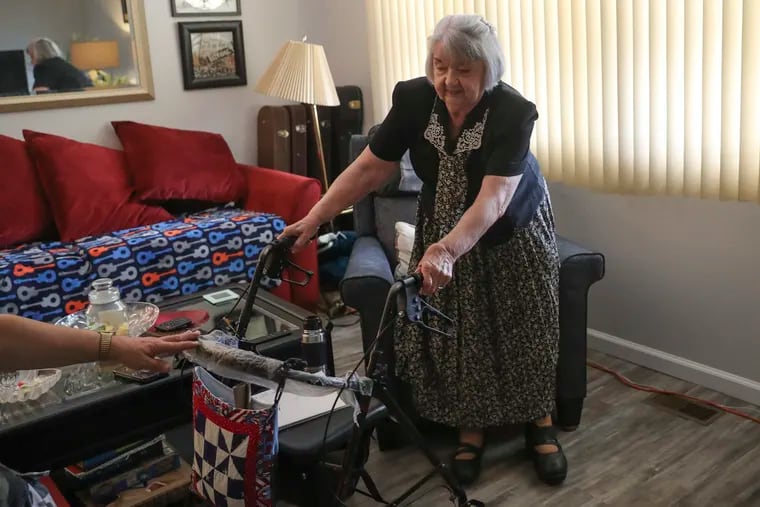 Charlotte Clarkson, 80, struggling to stand up while inside her home in Northeast Philadelphia earlier this fall. Clarkson is wheelchair-bound because of polio, which she got when she was 9, because the vaccine was not yet available in the U.S.