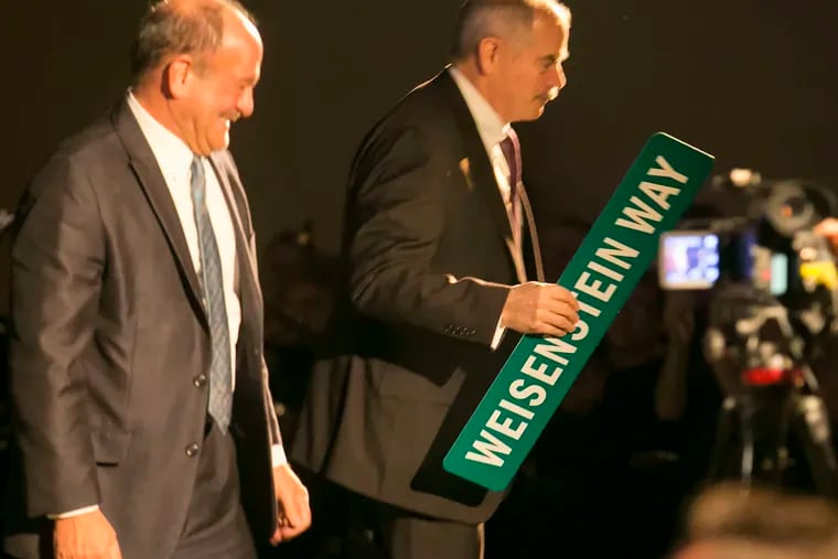 Greg R. Weisenstein is honored on his retirement as West Chester University's president this month by having a street named after him. Retired professor John Baker made the presentation. Weisenstein said the school, the only one in the state system whose enrollment rose last year, was looking to expand off-site. Story, B2. ED HILLE / Staff Photographer