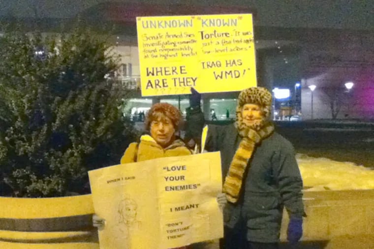 Barbara Quintiliano (left) and Ann Agee (right) were protesting in front of the National Constitution Center where Donald Rumsfeld was discussing details from his new book. (Jan Ransom / Staff)