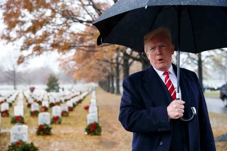President Donald Trump speaks to media he visits Section 60 at Arlington National Cemetery in Arlington, Va., Saturday, Dec. 15, 2018, during Wreaths Across America Day. Wreaths Across America was started in 1992 at Arlington National Cemetery by Maine businessman Morrill Worcester and has expanded to hundreds of veterans' cemeteries and other locations in all 50 states and beyond. (AP Photo/Carolyn Kaster)