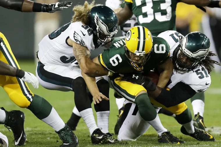Quarterback Joe Callahan gets sacked by the Eagles’ Steven Means (right) and defensive back Aaron Grymes a preseason game in 2017.