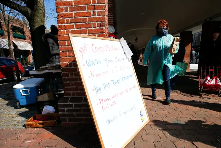 A board with a list of rules for shoppers at the Headhouse Farmers' Market in the Society Hill section of Philadelphia on Sunday, March 22, 2020.  The market is open even after Gov. Tom Wolf called for the closure of all businesses that are not "life-sustaining," due to the spread of the coronavirus.