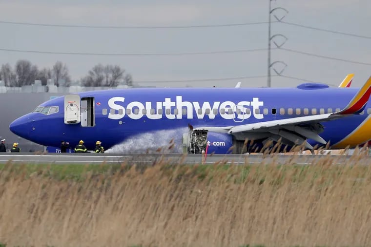 Firefighters spray a Southwest Airlines plane with a damaged engine at Philadelphia International Airport in Philadelphia, PA on April 17, 2018. The plane made an emergency landing.