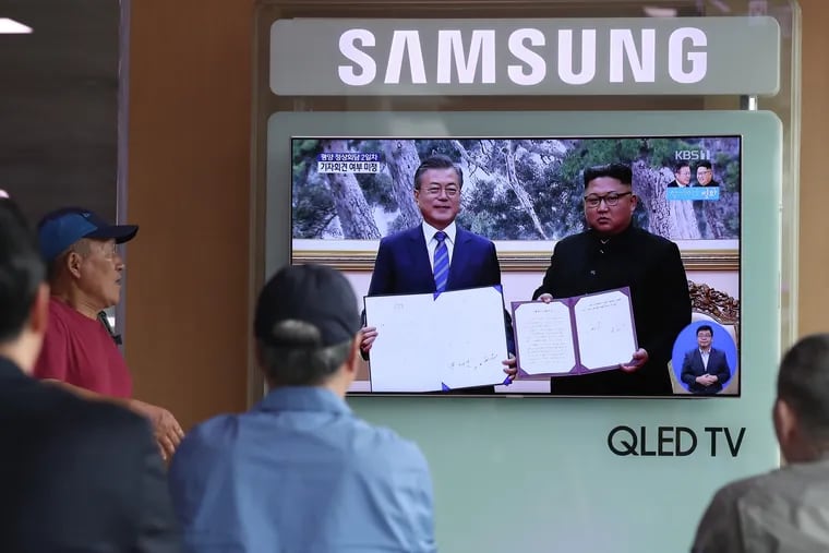 People at Seoul Station in Seoul, South Korea, watch a TV screen featuring South Korean President Moon Jae-in (left) and North Korean leader Kim Jong-un attending a news conference in Pyongyang, North Korea, on Sept. 19, 2018.